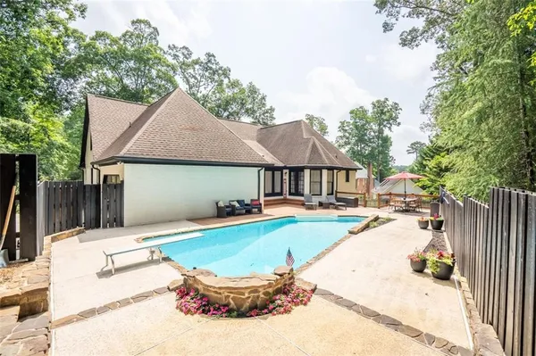 a view of a house with swimming pool and sitting area