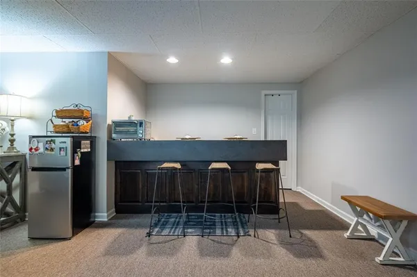 a kitchen with refrigerator and chair