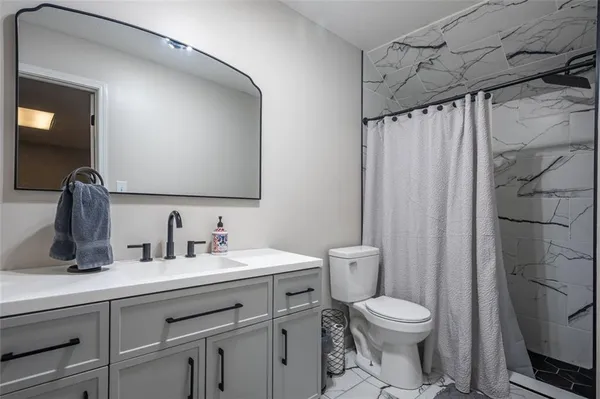 a bathroom with a toilet sink and mirror