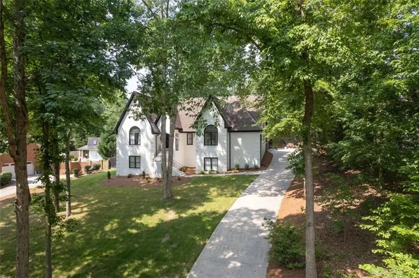 a view of a house with backyard and trees