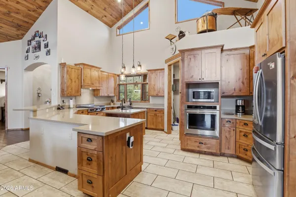 a kitchen with stainless steel appliances granite countertop a sink and a refrigerator