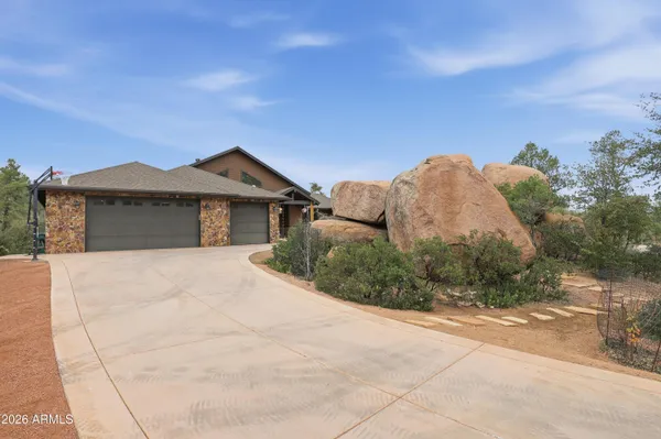 a view of a house with a yard and large tree