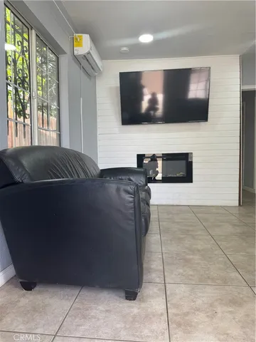 a living room with a bed furniture and a flat screen tv