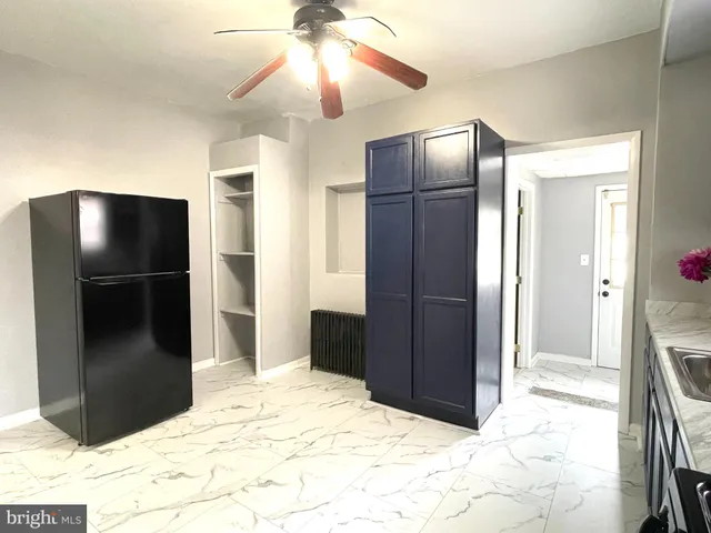 a kitchen with stainless steel appliances granite countertop a refrigerator and a chandelier