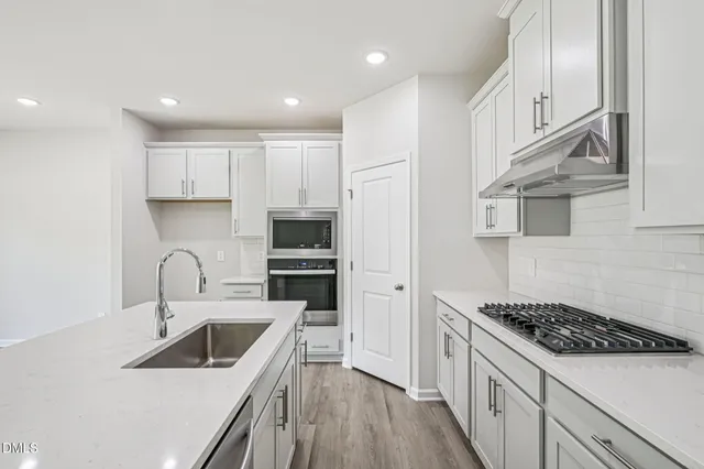 a view of kitchen with stainless steel appliances refrigerator microwave and stove