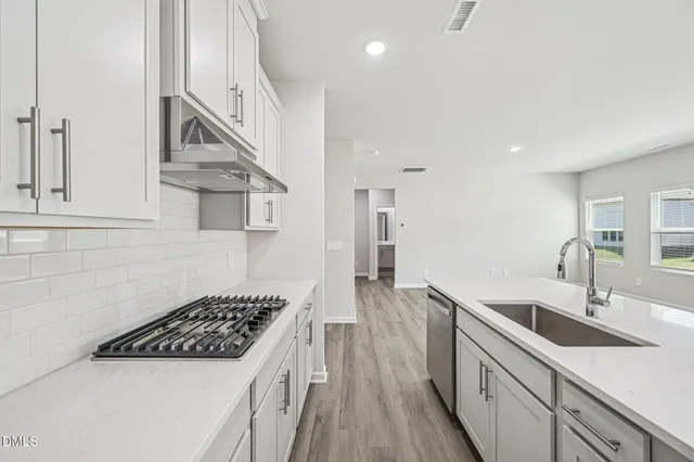 a kitchen with stainless steel appliances a stove a sink a refrigerator and cabinets