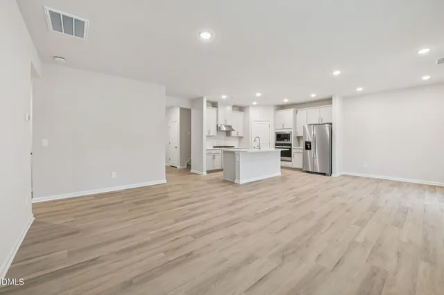 a kitchen with stainless steel appliances white cabinets and a refrigerator