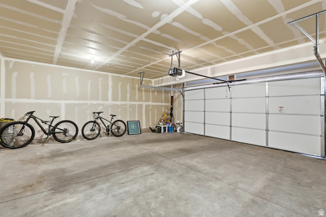 2216 South 1150 West Nibley, UT 84321 - Photo 30 of 34 Spacious garage featuring a concrete floor, an overhead garage door, and an automatic garage door opener