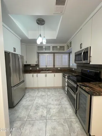 a kitchen with stainless steel appliances granite countertop a refrigerator a sink a stove a microwave and island