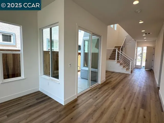 a view of a hallway with wooden floor and staircase