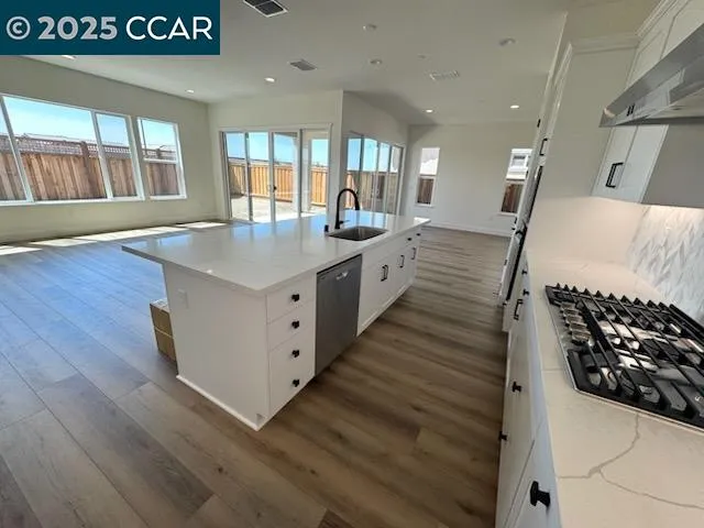 a kitchen with kitchen island white cabinets appliances and sink
