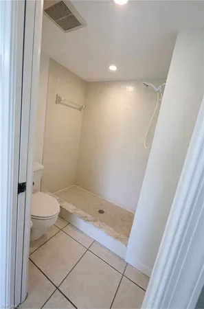a bathroom with a granite countertop shower and a toilet