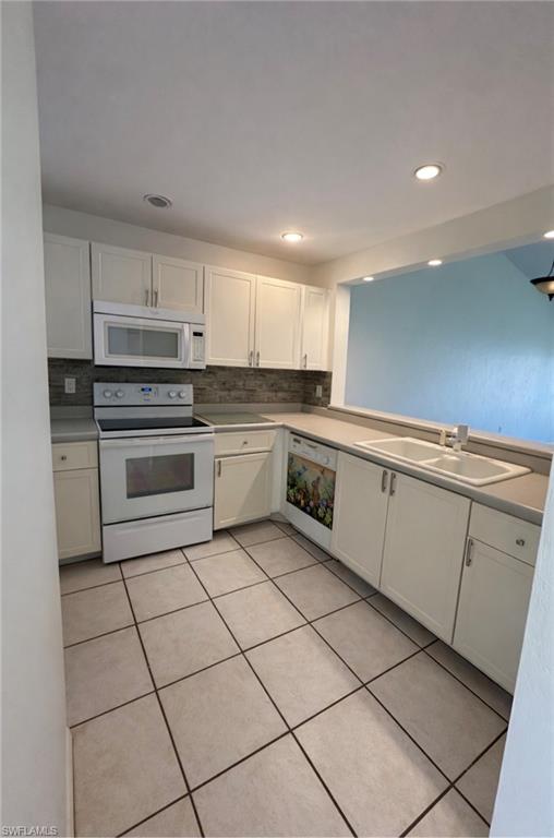 1228 Commonwealth Circle, Unit O203 Naples, FL 34116 - Photo 15 of 17 a kitchen with white cabinets appliances and a sink