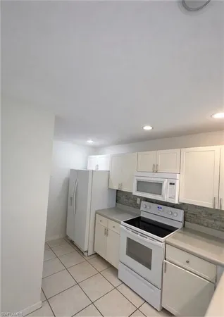 a kitchen with stainless steel appliances granite countertop a sink and a refrigerator