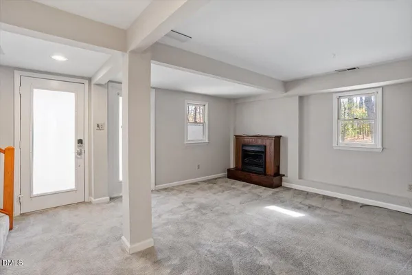 a view of an empty room with window and closet area