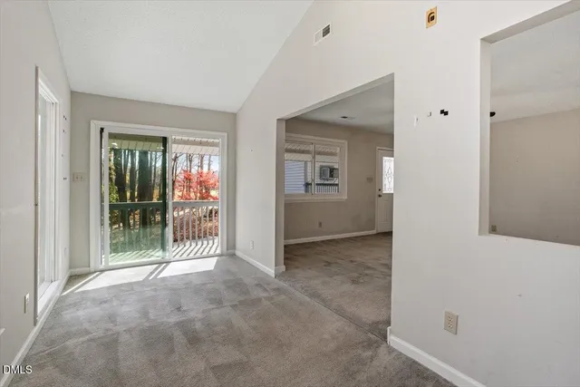 a view of a hallway with wooden floor and a door