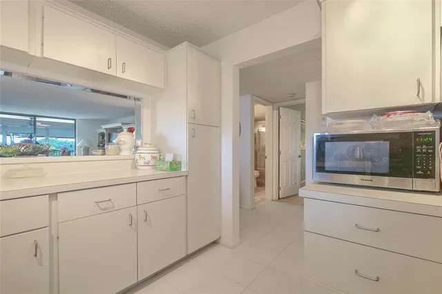 a view of a backyard with potted plants and large trees