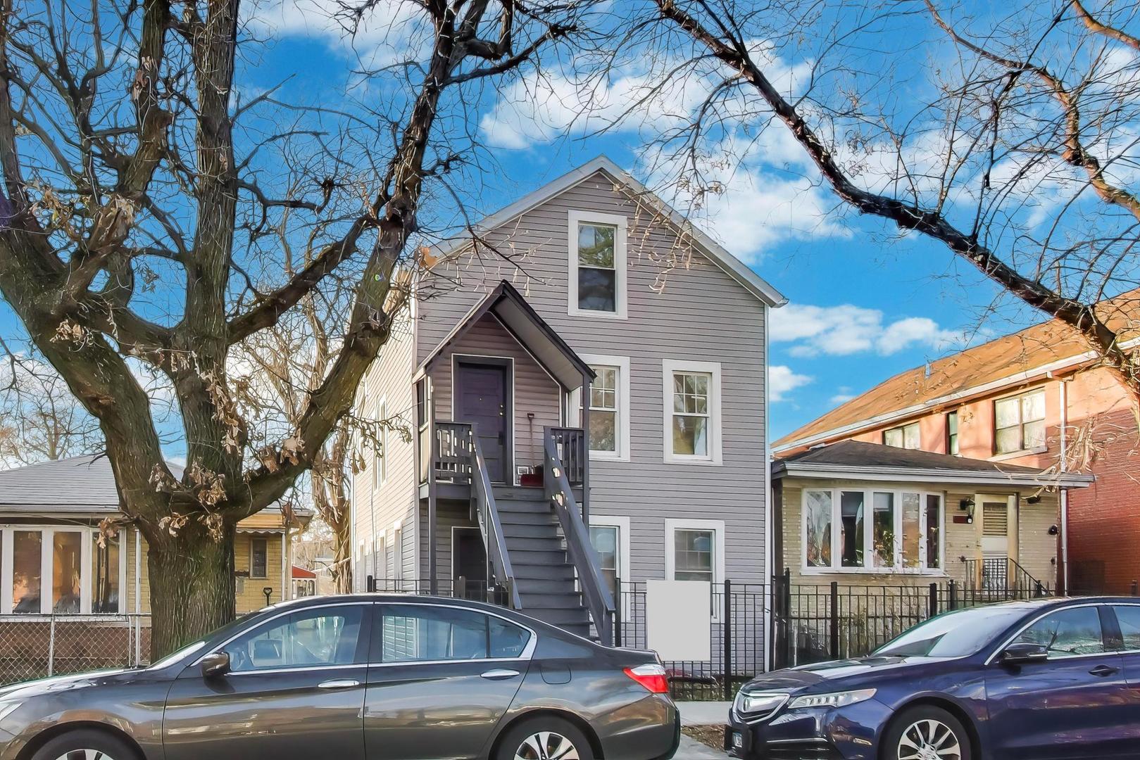 a front view of a house with cars parked