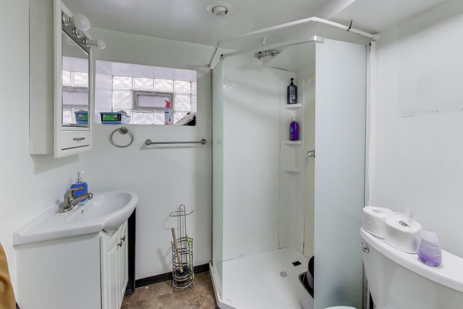 3248 South Paulina Street Chicago, IL 60608 - Photo 35 of 43 a bathroom with a sink mirror toilet and shower