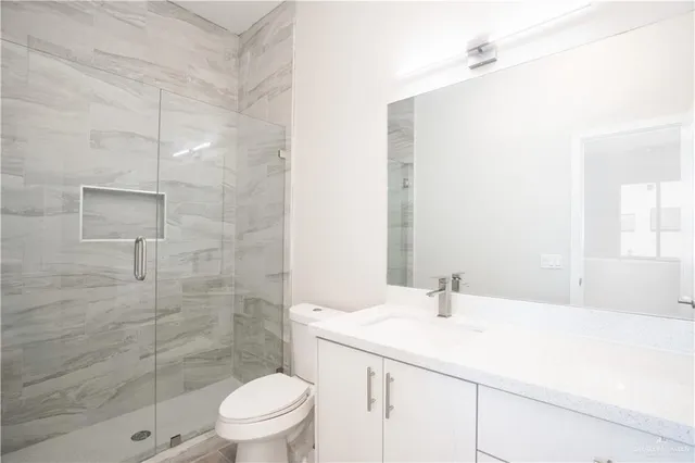 a view of wooden floor and a chandelier fan in a room