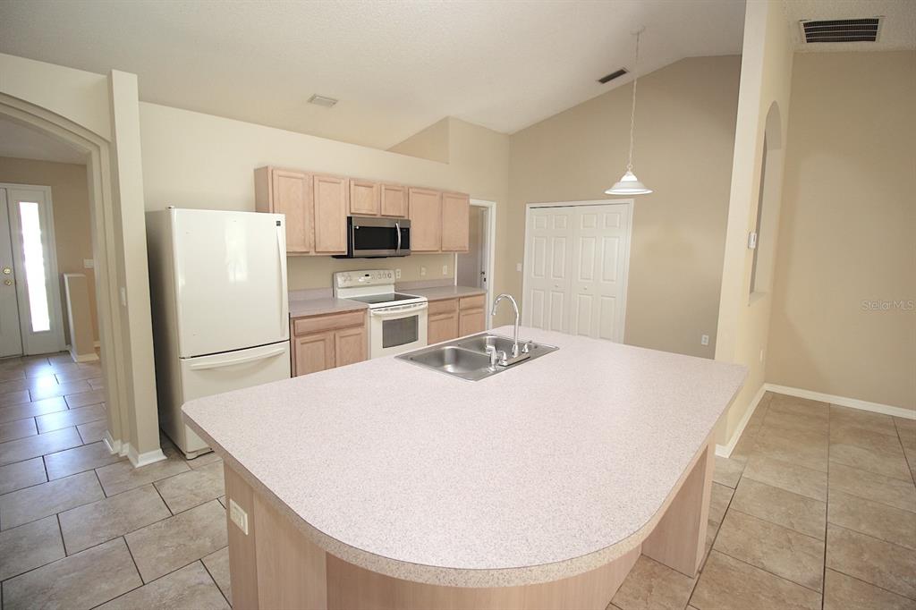 32 Ryding Lane Palm Coast, FL 32164 - Photo 13 of 38 a large white kitchen with a sink a refrigerator and a stove