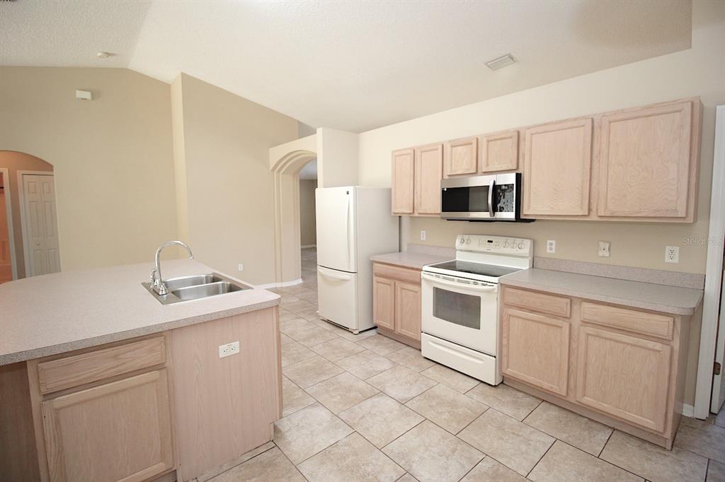 32 Ryding Lane Palm Coast, FL 32164 - Photo 18 of 38 a kitchen with white cabinets stainless steel appliances and a sink