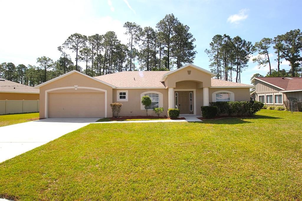 32 Ryding Lane Palm Coast, FL 32164 - Photo 2 of 38 a front view of a house with a garden