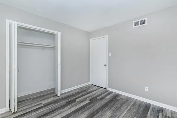 a view of a room with wooden floor and closet