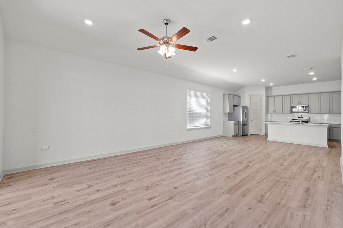 2201 Bobtail Pass Leander, TX 78641 - Photo 12 of 30 a view of an empty room with a window and wooden floor
