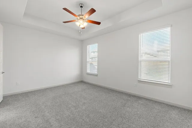 an empty room with a window and a fan