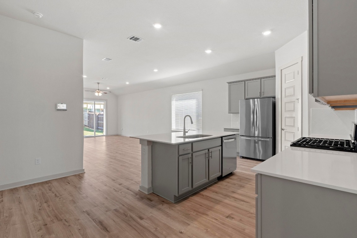 2201 Bobtail Pass Leander, TX 78641 - Photo 6 of 30 a kitchen with stainless steel appliances a refrigerator and a stove top oven