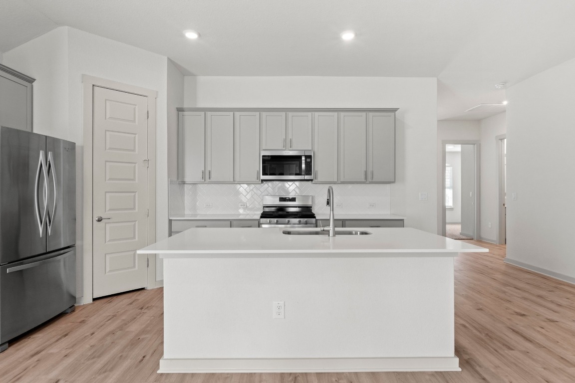 2201 Bobtail Pass Leander, TX 78641 - Photo 7 of 30 a kitchen with kitchen island a sink stainless steel appliances and cabinets