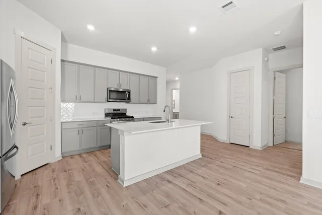 a large kitchen with a white stove top oven and white cabinets