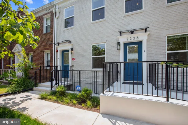 a view of a house with a small yard and flower plants