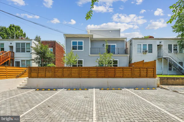 a front view of a house with a yard and potted plants