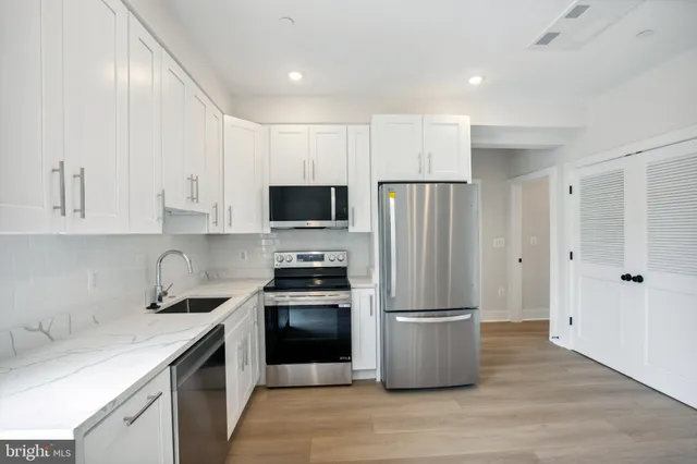a kitchen with a refrigerator sink and stainless steel appliances