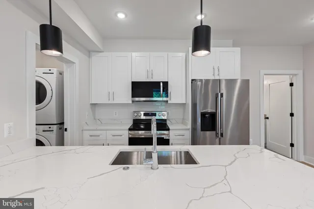 a kitchen with stainless steel appliances kitchen island granite countertop a refrigerator and a stove top oven