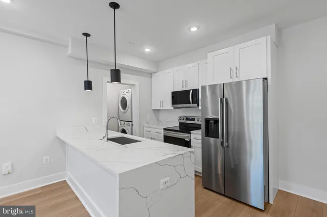 a kitchen with kitchen island a sink stainless steel appliances and cabinets