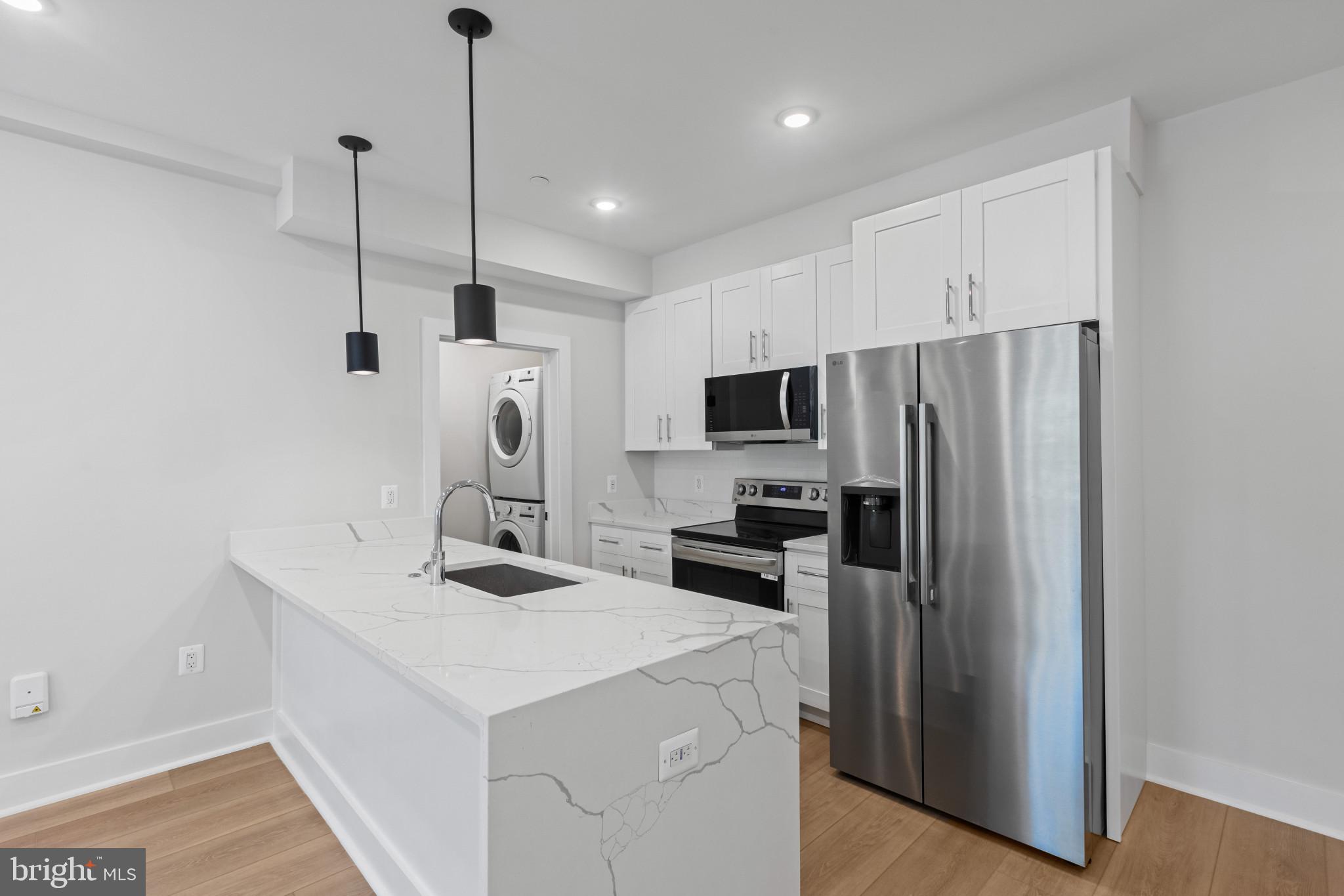 2236 40th Street Northwest, Unit FIVE Washington, DC 20007 - Photo 7 of 37 a kitchen with kitchen island a sink stainless steel appliances and cabinets