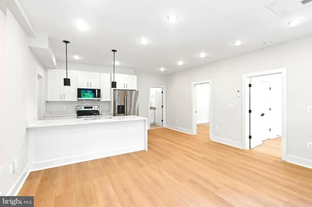 a kitchen with stainless steel appliances kitchen island granite countertop a refrigerator and a sink