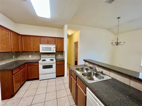 a kitchen with a stove sink and cabinets