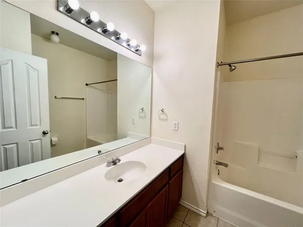 a bathroom with a tub a sink and mirror