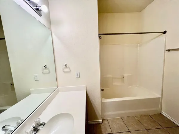 a bathroom with a sink a mirror and a bath tub