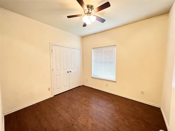 an empty room with a window and a ceiling fan