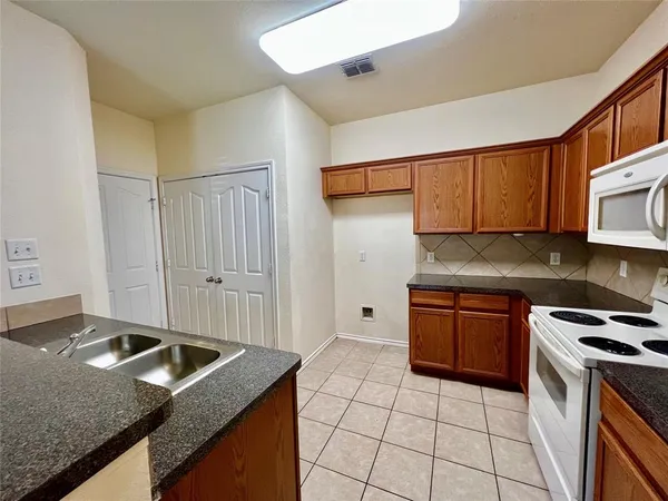 a kitchen with stainless steel appliances granite countertop a stove a sink and a microwave