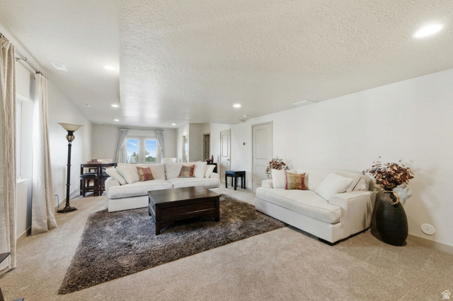 987 East Deer Arch Lane Draper, UT 84020 - Photo 32 of 46 Large basement living room featuring carpet floors, a textured ceiling, and recessed lighting