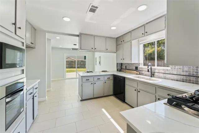 a kitchen with a sink stove and cabinets