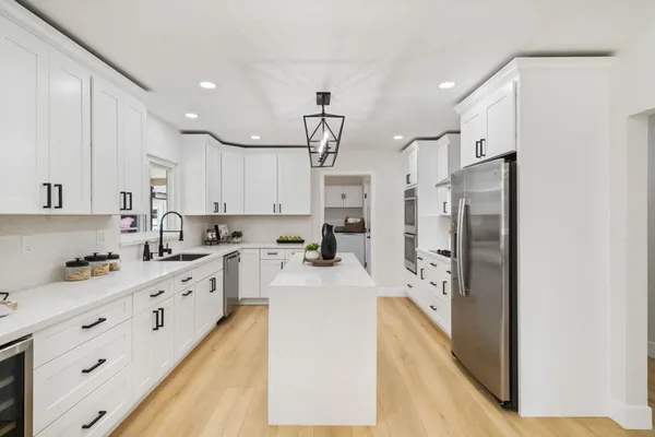 a kitchen with stainless steel appliances a refrigerator sink and cabinets