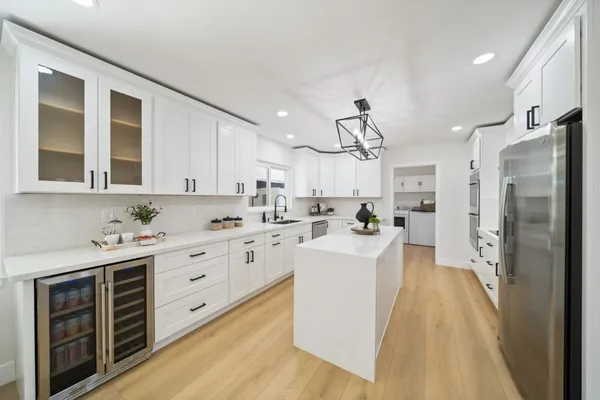 a kitchen with white cabinets and stainless steel appliances