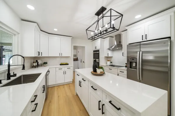 a kitchen with stainless steel appliances granite countertop a sink a stove and refrigerator